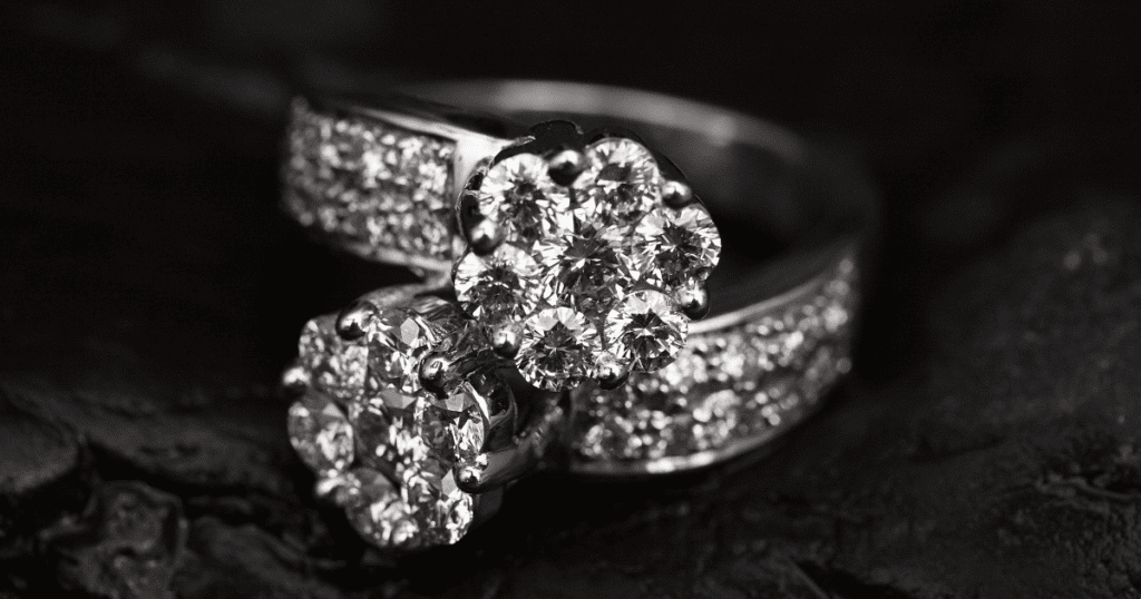 A close-up of two stunning diamond rings with intricate designs and brilliant-cut diamonds, set against a dark background.