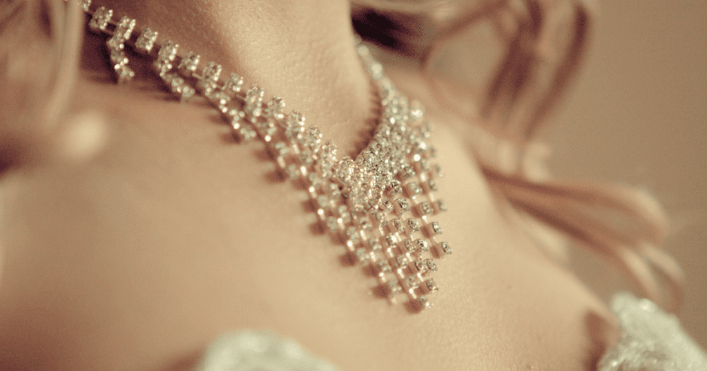 Close-up of a woman's neck adorned with a sparkling diamond necklace featuring an intricate, cascading design that exudes elegance and sophistication.