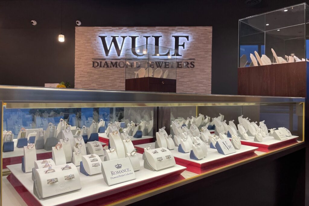 Wulf Diamond Jewelers showroom displays an array of elegant diamond rings in glass cases, showcasing luxury bridal collections under soft lighting.