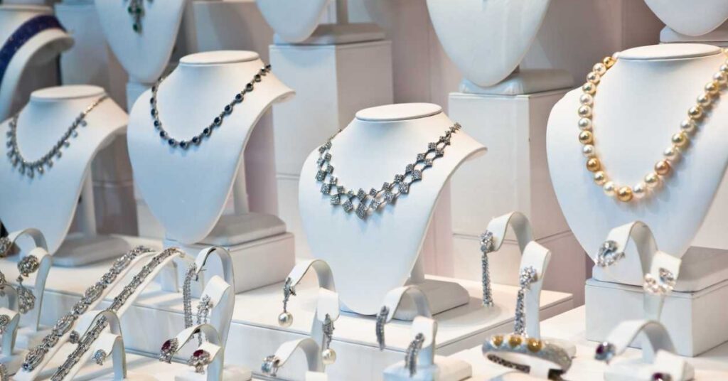 A jewelry display showcasing necklaces, bracelets, earrings and a ring in various styles on white mannequins. 