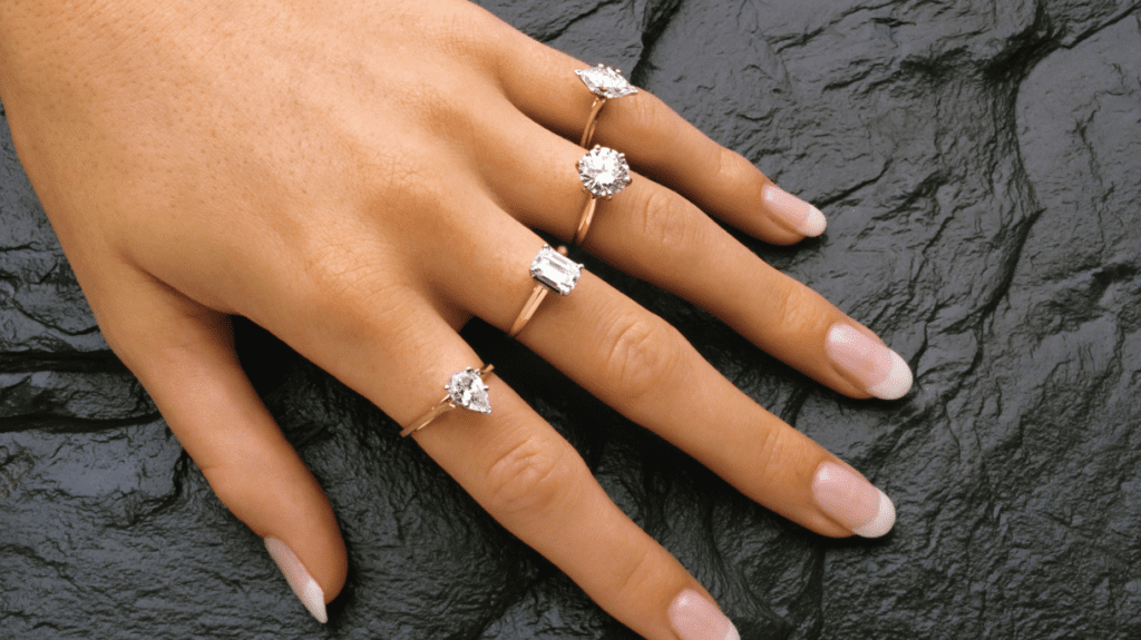 Three gold rings grace a woman's hand, each one reflecting a unique style. 