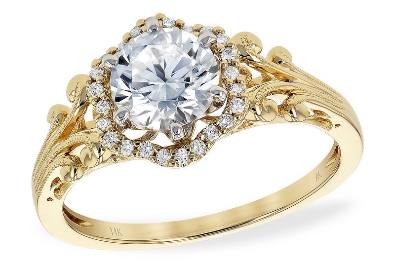 A 14K gold engagement ring with an intricate vintage design, featuring a large round diamond centerpiece surrounded by a halo of smaller diamonds.