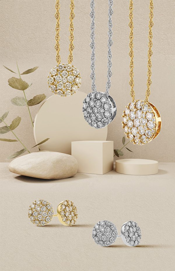 Elegant gold and silver jewelry set featuring sparkling round pendants and matching stud earrings, displayed on a minimalist beige background.