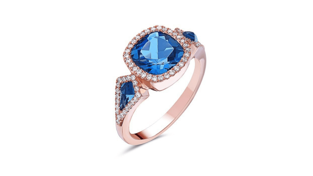 Stunning blue topaz ring featuring a cushion-cut center stone and diamond side stones.