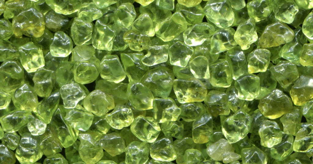 A cluster of green peridot stones, highlighting their unique shape and translucent appearance.