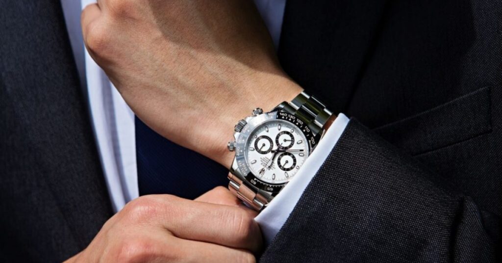 Elegant Rolex Cosmograph Daytona watch with a white dial and stainless steel bracelet, worn on a man's wrist.