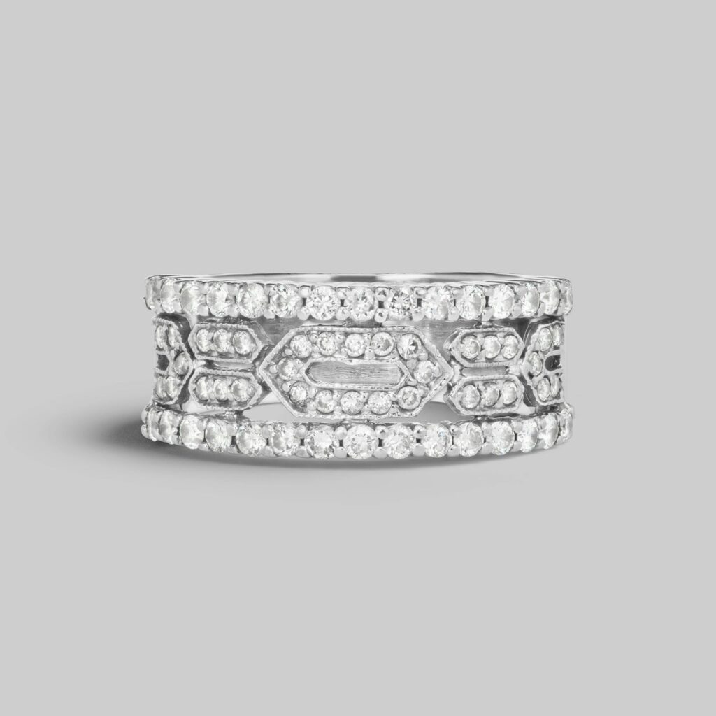 Intricately designed diamond band with geometric patterns and rows of sparkling stones, set in polished white gold, offering a bold yet refined look.