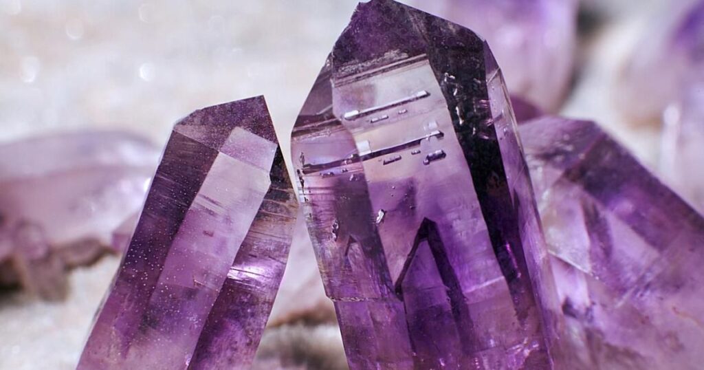 A cluster of purple amethyst crystals with a pointed shape.