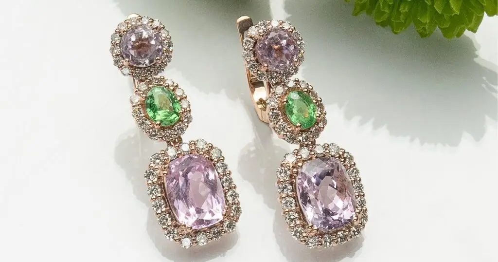 Elegant rose gold earrings featuring purple and green gemstones, each surrounded by sparkling diamonds, arranged in a cascading, vintage style.