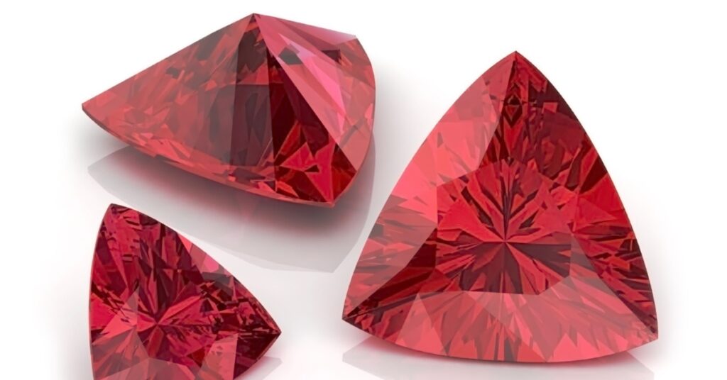 Three trillion-cut ruby gemstones with a vibrant red color.