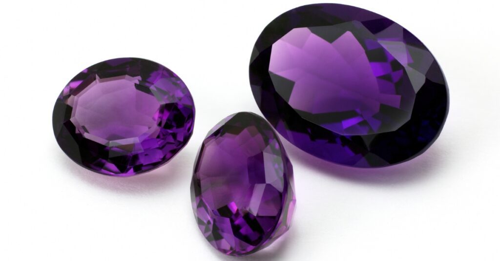 Three amethyst gemstones in different sizes and cuts.