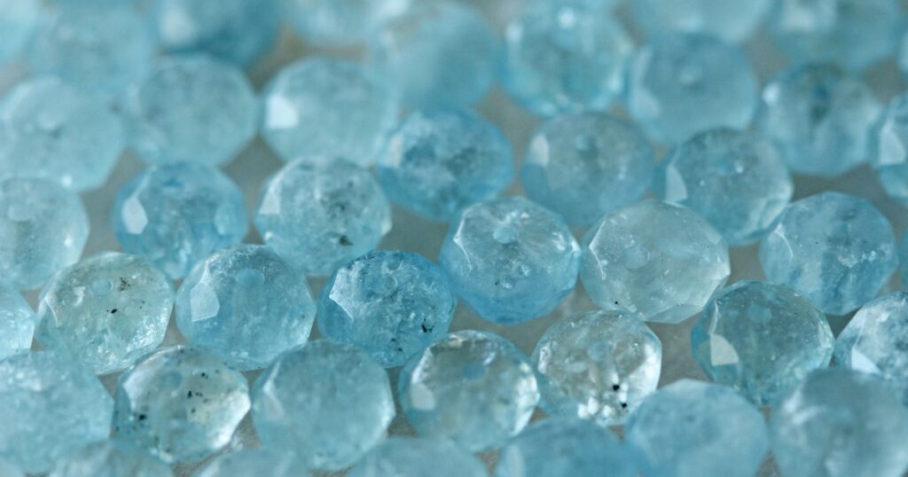  A cluster of small, round aquamarine gemstones with a light blue color.