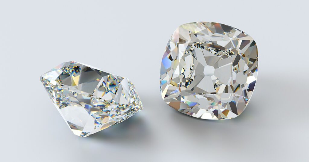 Two cushion-cut diamonds showcasing intricate facets and brilliant sparkle, set against a light gray background to highlight their clarity and brilliance.