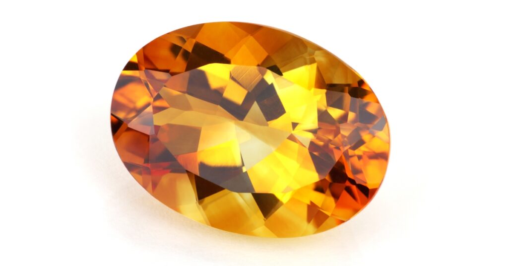 An oval-shaped citrine gemstone with a bright yellow color.