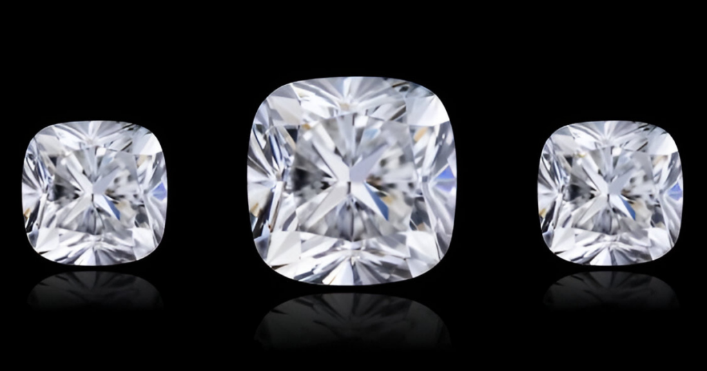 Three cushion-cut diamonds of varying sizes, displayed on a black background.