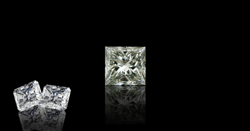 Three princess-cut diamonds of different sizes on a black background.