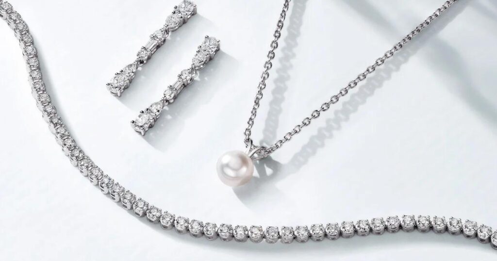 A stunning diamond jewelry set, featuring a pear-shaped diamond pendant necklace, a tennis bracelet, and a pair of matching pear-shaped diamond earrings.