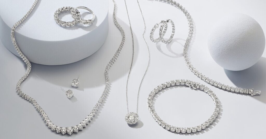 A collection of diamond jewelry, including necklaces, bracelets, earrings, and rings, arranged on a white background.