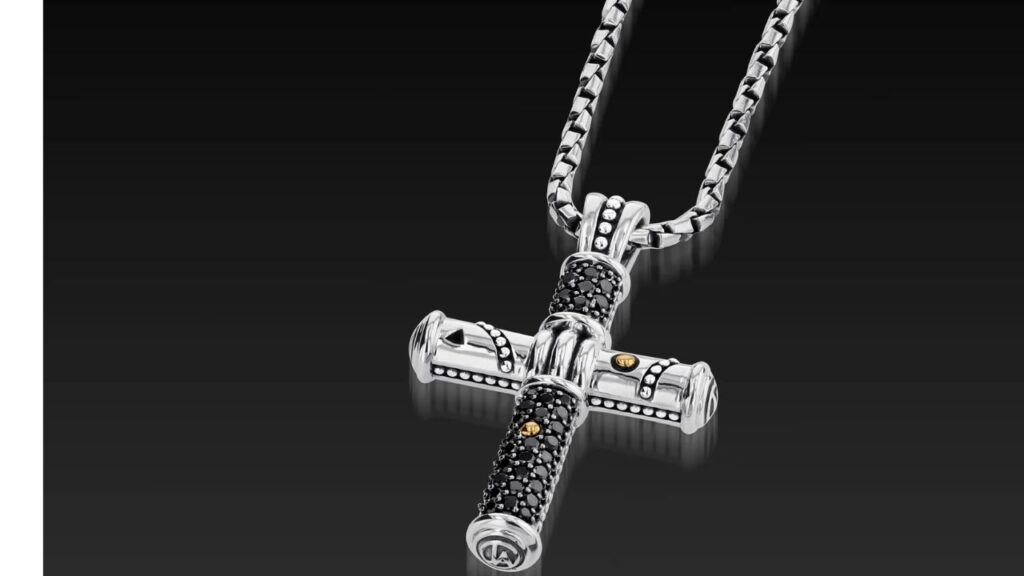 A striking silver cross pendant with black diamonds and gold accents, hanging from a bold chain.