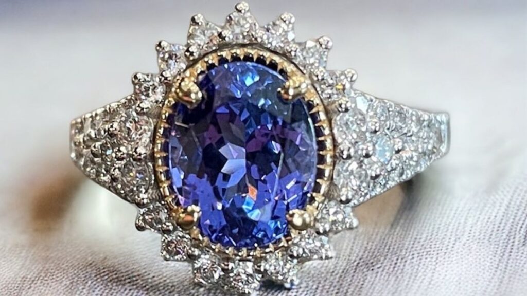 A luxurious ring with a rich blue sapphire, set in a halo of diamonds and a sophisticated design.