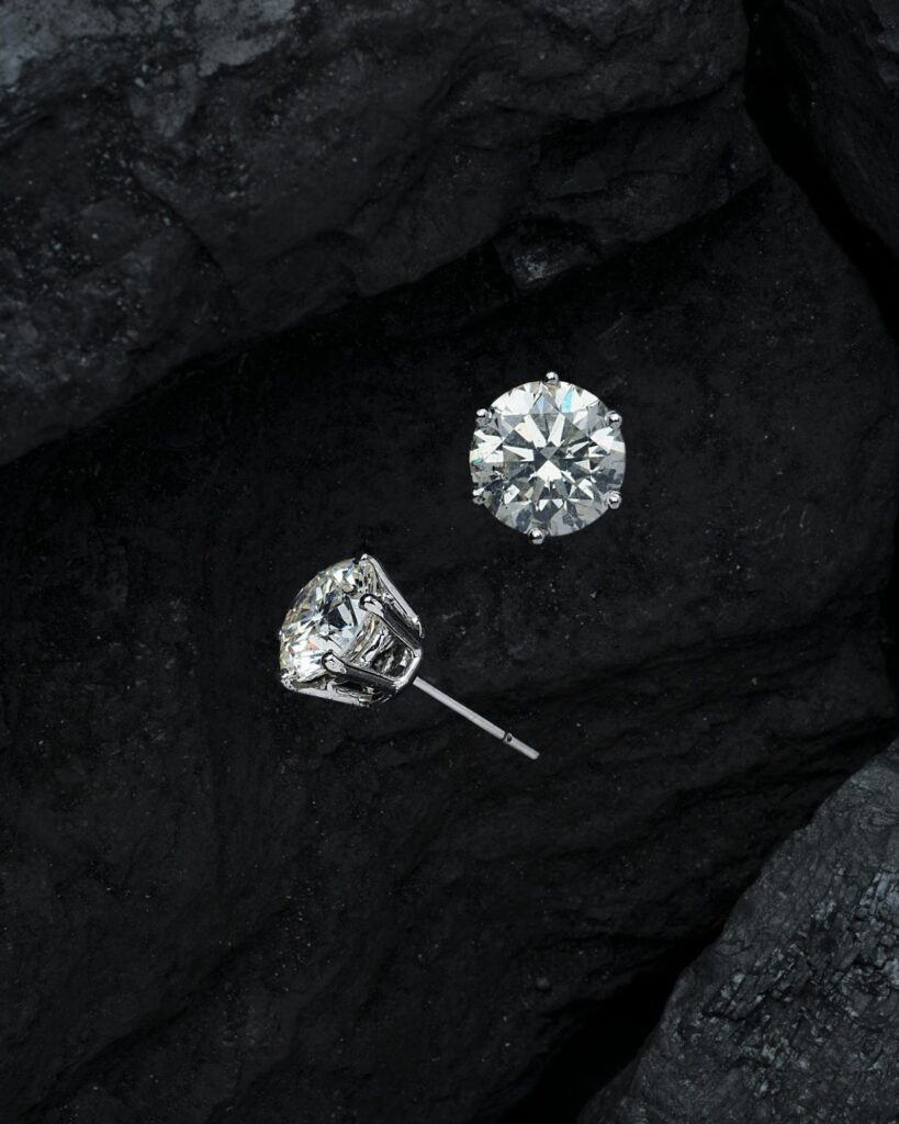 Dazzling diamond studs set against a backdrop of dark stone, exuding elegance and sophistication.