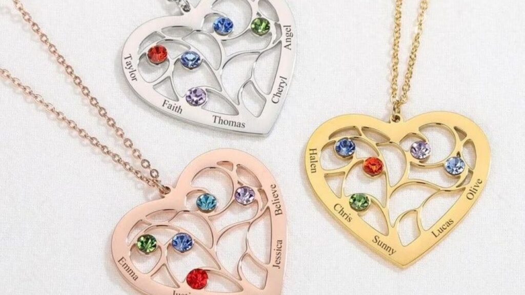 A collection of personalized heart-shaped necklaces, each adorned with birthstones and engraved with family names.