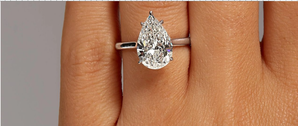 A marquise-cut diamond sparkling with light, casting a subtle shadow on a white background.