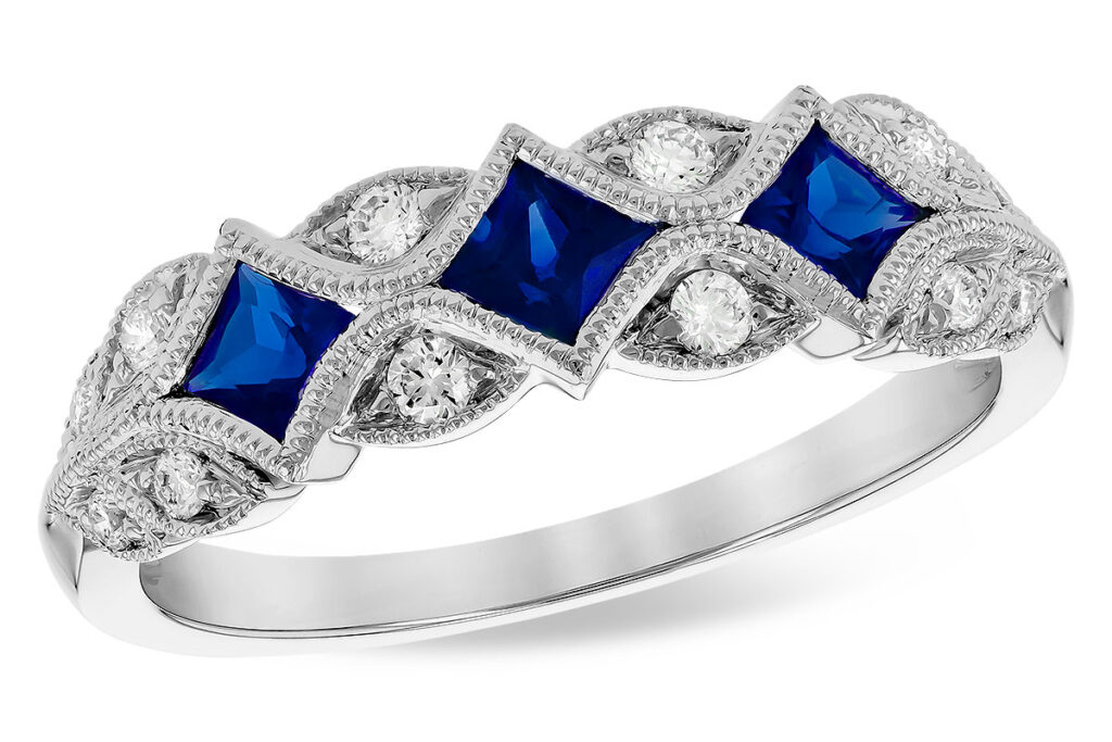 Anniversary ring featuring several round diamonds with sapphire accents.