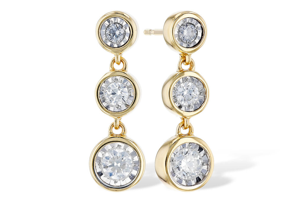 A pair of gold drop earrings featuring three bezel-set diamonds each, displayed on a white background.