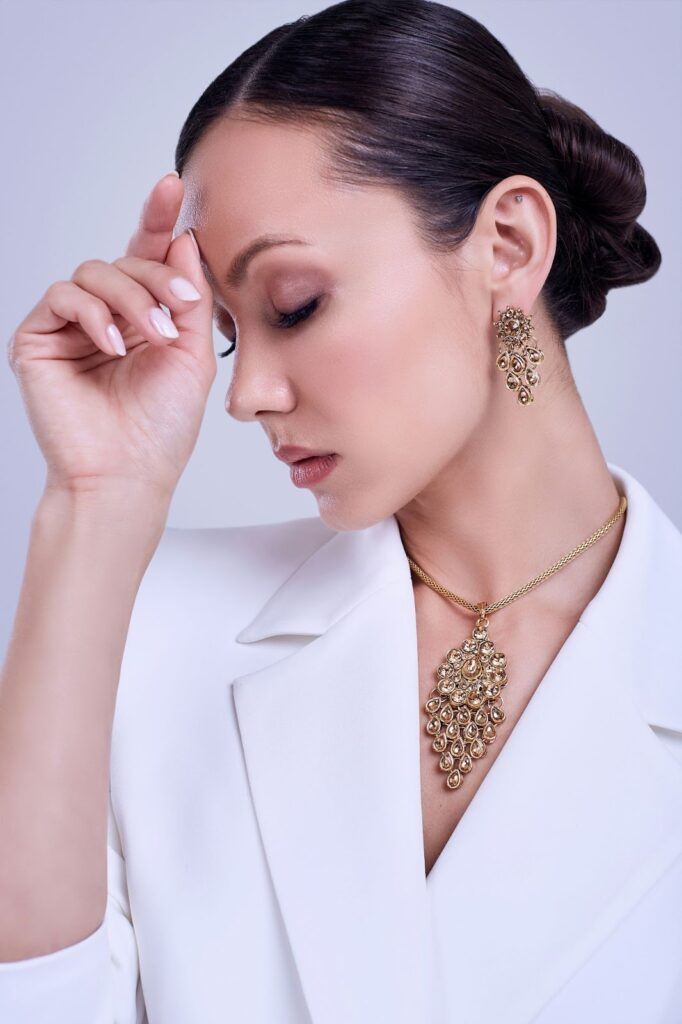Woman with Jewelry And Watches: a necklace and earrings with a floral design, paired with a white blazer.
Sources and related content