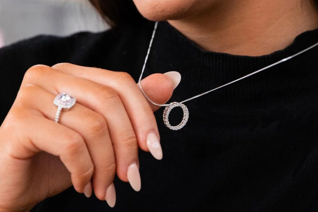 A woman's hand displaying Jewelry and watches: a ring and a necklace.