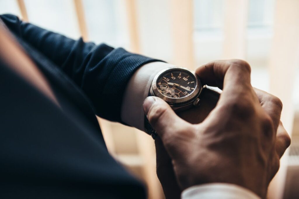 Close-up of a man in a suit checking his elegant Office Watch.