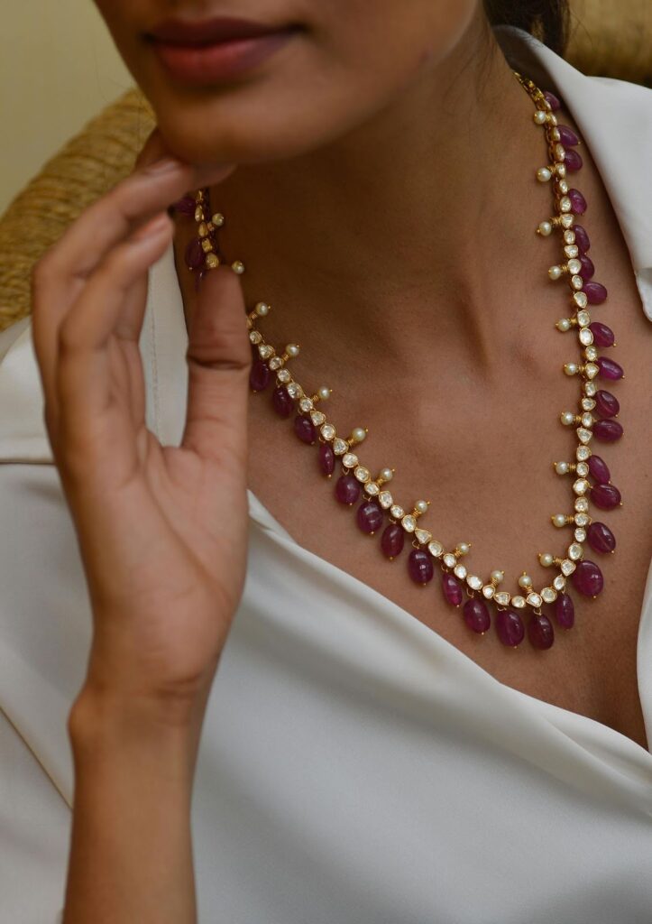 A necklace with red teardrop-shaped jewels and small pearls, enhancing personal style as Jewelry to impress boss from Wulf Diamond Jewelers.