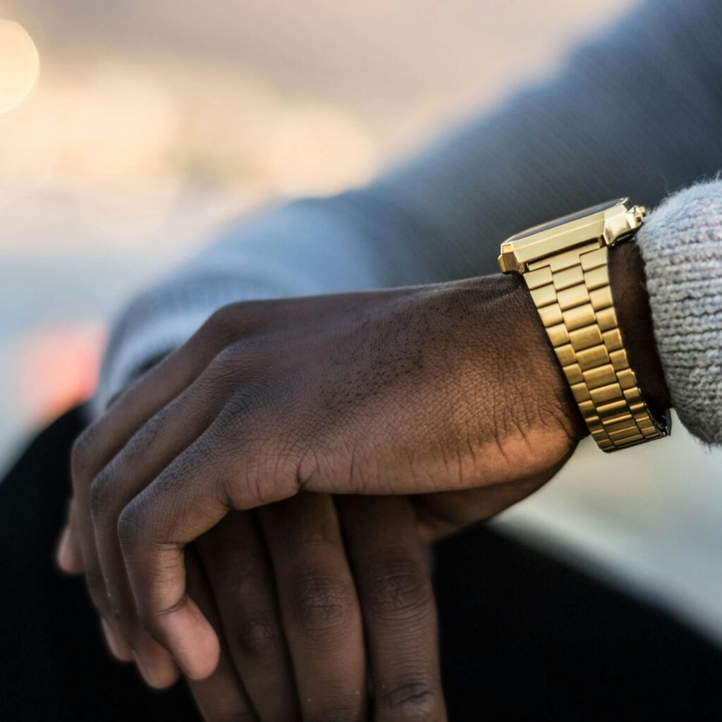 A man wearing a stylish gold watch, highlighting Jewelry to impress boss, available at Wulf Diamond Jewelers.