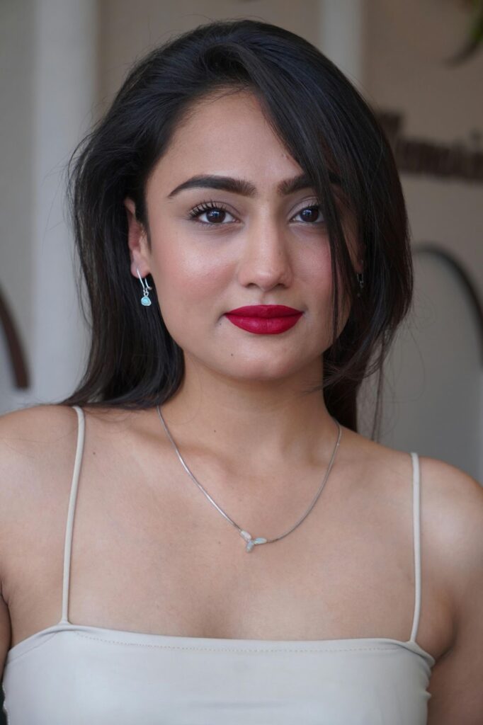 A beautiful woman wearing subtle earrings and a delicate necklace, highlighting Jewelry to impress boss from Wulf Diamond Jewelers.