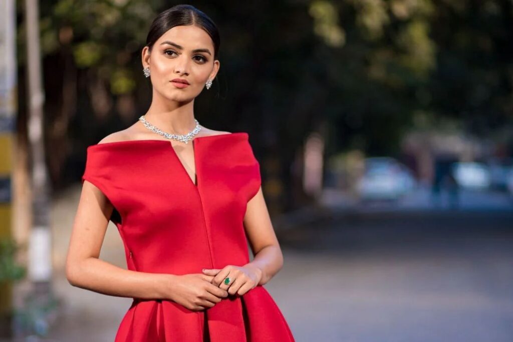 A elegant woman in a red off-shoulder gown with diamond jewelry, perfect for a Work holiday party from Wulf Diamond Jewelers.