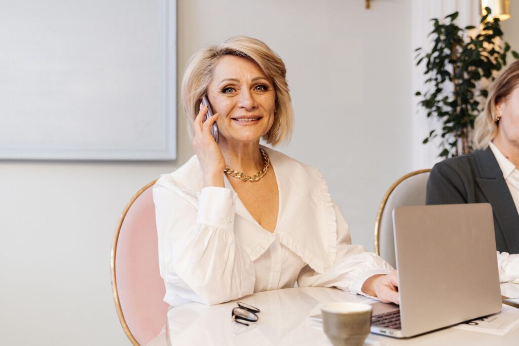A professional woman in a blazer wearing hoop earrings and a necklace, showcasing Office Jewelry Essentials.