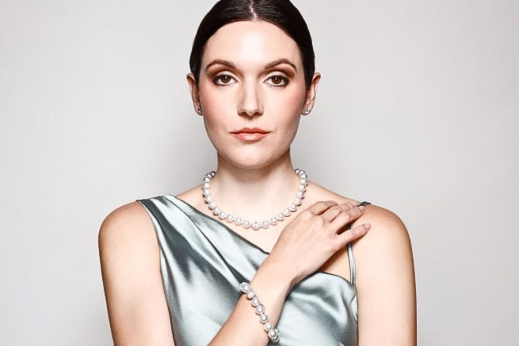 A professional woman with elegant diamond and emerald jewelry, perfect for a Work holiday party from Wulf Diamond Jewelers.