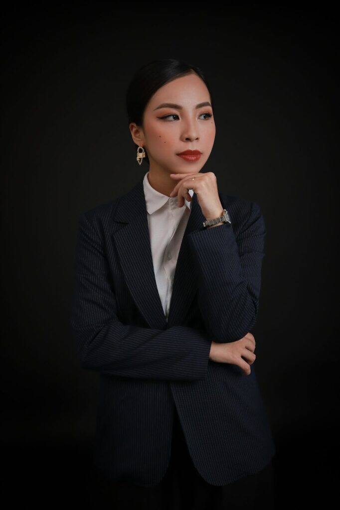 A striking image of a woman with her hand on her chin, wearing earrings, a watch, and a ring, highlighting exquisite Jewelry Choices from Wulf Diamond Jewelers.
