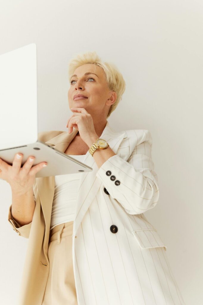 A confident businesswoman in a striped blazer and watch, part of a professional duo displaying Jewelry and Watches from Wulf Diamond Jewelers.