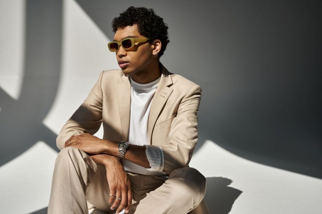 A male professional wearing stylish sunglasses and a watch, highlighting Professional accessories for work from Wulf Diamond Jewelers.