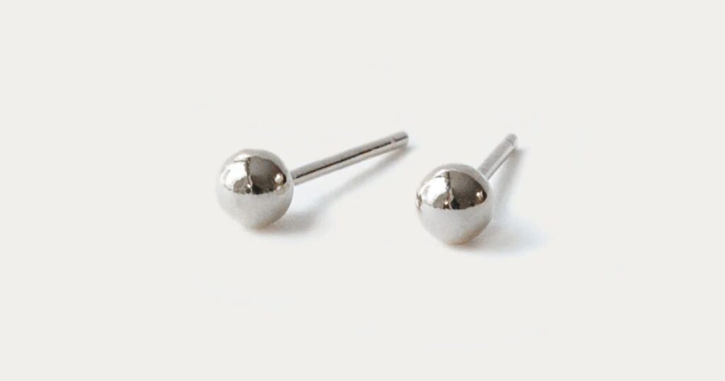 Elegant and refined pearl drop earrings with a gold-tone circle design from Wulf Diamond Jewelers' minimalist vacation jewelry collection.